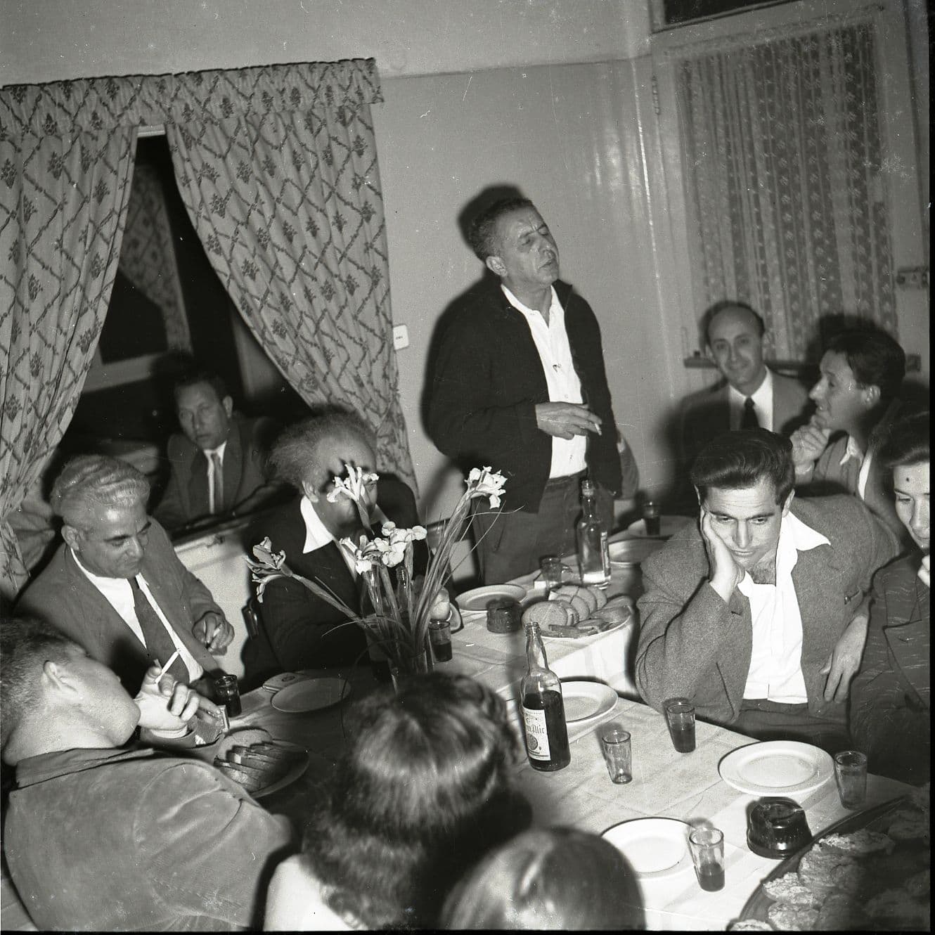 נתן אלתרמן נושא נאום בקפה &quot;כסית&quot; כשמסביבו אנשי הבוהמה. ראשון משמאל: המשורר רפאל אליעז. אפריל 1955 (צילום: ארכיון בוריס כרמי, הספרייה הלאומית)