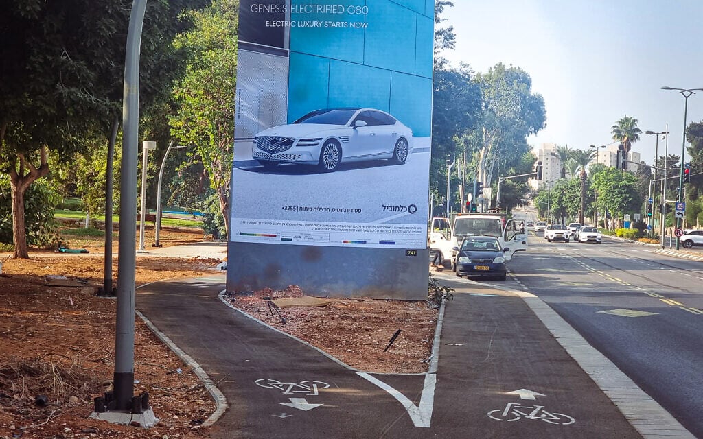 שלט פרסומי המפצל את שבילי האופניים בדרך משה סנה (צילום: אביב לביא)