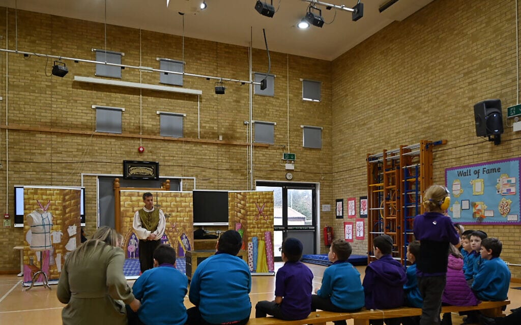 מורה מרגיעה תלמיד בעת הצגה בבית הספר &quot;גשר&quot;, לונדון, 7 במרץ 2022 (צילום: כנען ליפשיץ)