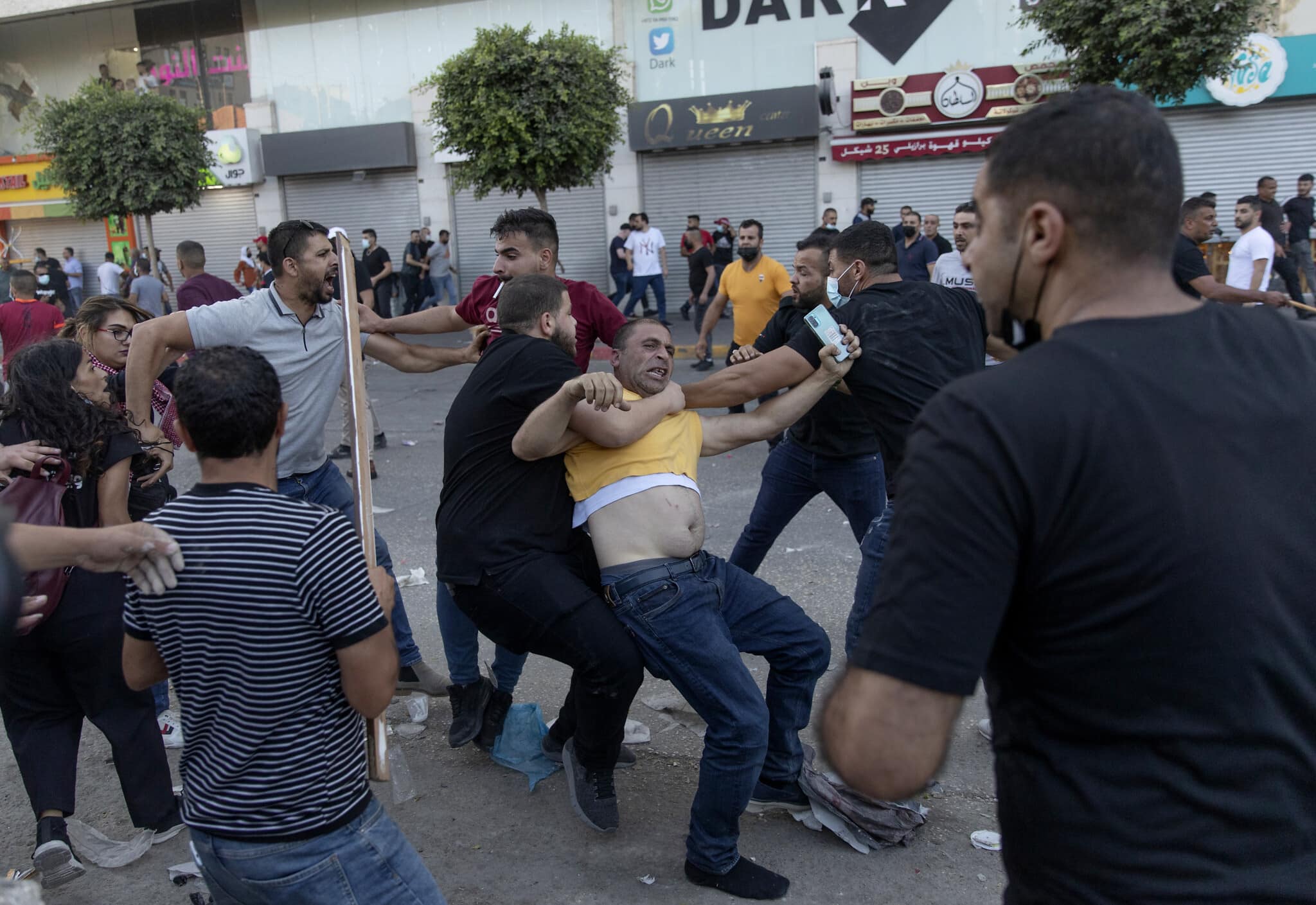 שוטרים פלסטינים בלבוש אזרחי עוצרים מפגין במהלך מחאה על מותו של ניזאר בנאת. רמאללה, 26 ביוני 2021 (צילום: AP Photo/Nasser Nasser)