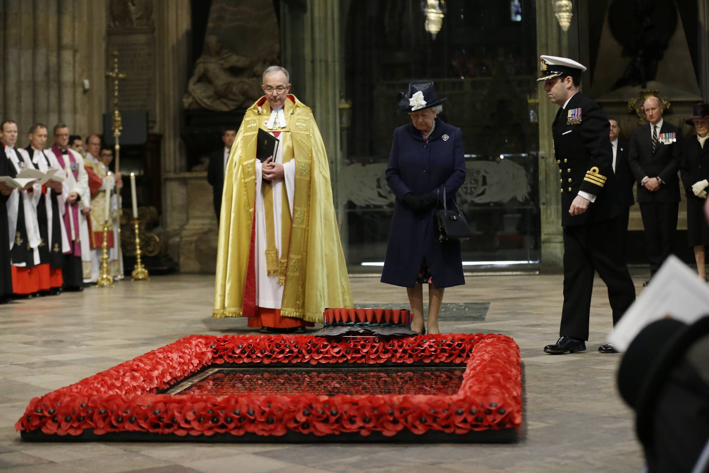 המלכה אליזבת השנייה וראש כנסיית וסטמינסטר עומדים לרגלי קבר החייל האלמוני בלב הכנסייה, במלאת 70 שנה לניצחון בנורמנדי, 10 במאי 2015 (צילום: AP Photo/Matt Dunham)