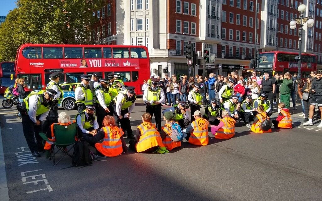 פעילי מחאה חוסמים את הכביש במרכז לונדון, 8 באוקטובר 2022 (צילום: Just Stop Oil)
