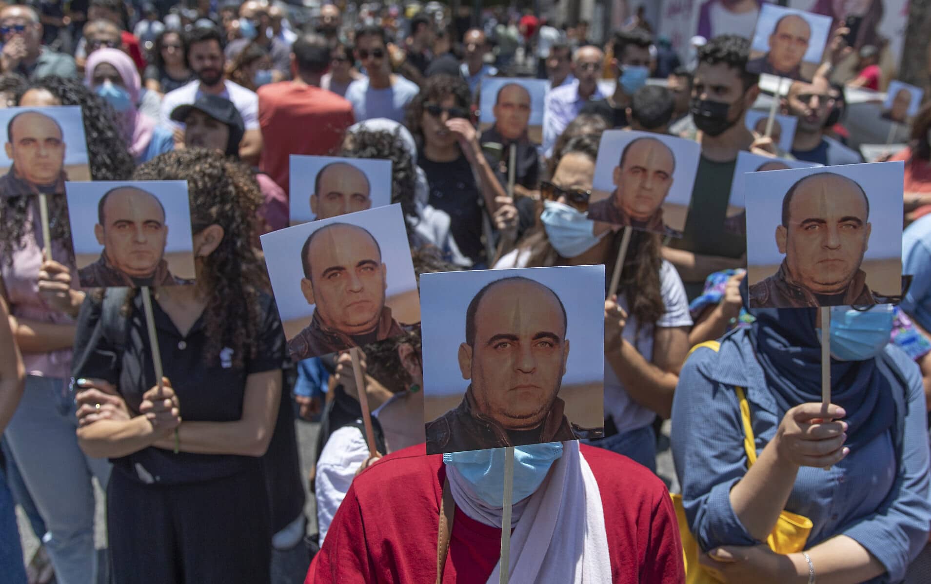 פלסטינים מפגינים עם תמונות של ניזאר בנאת אחרי מותו. רמאללה, 24 ביוני 2021 (צילום: AP Photo/Nasser Nasser)