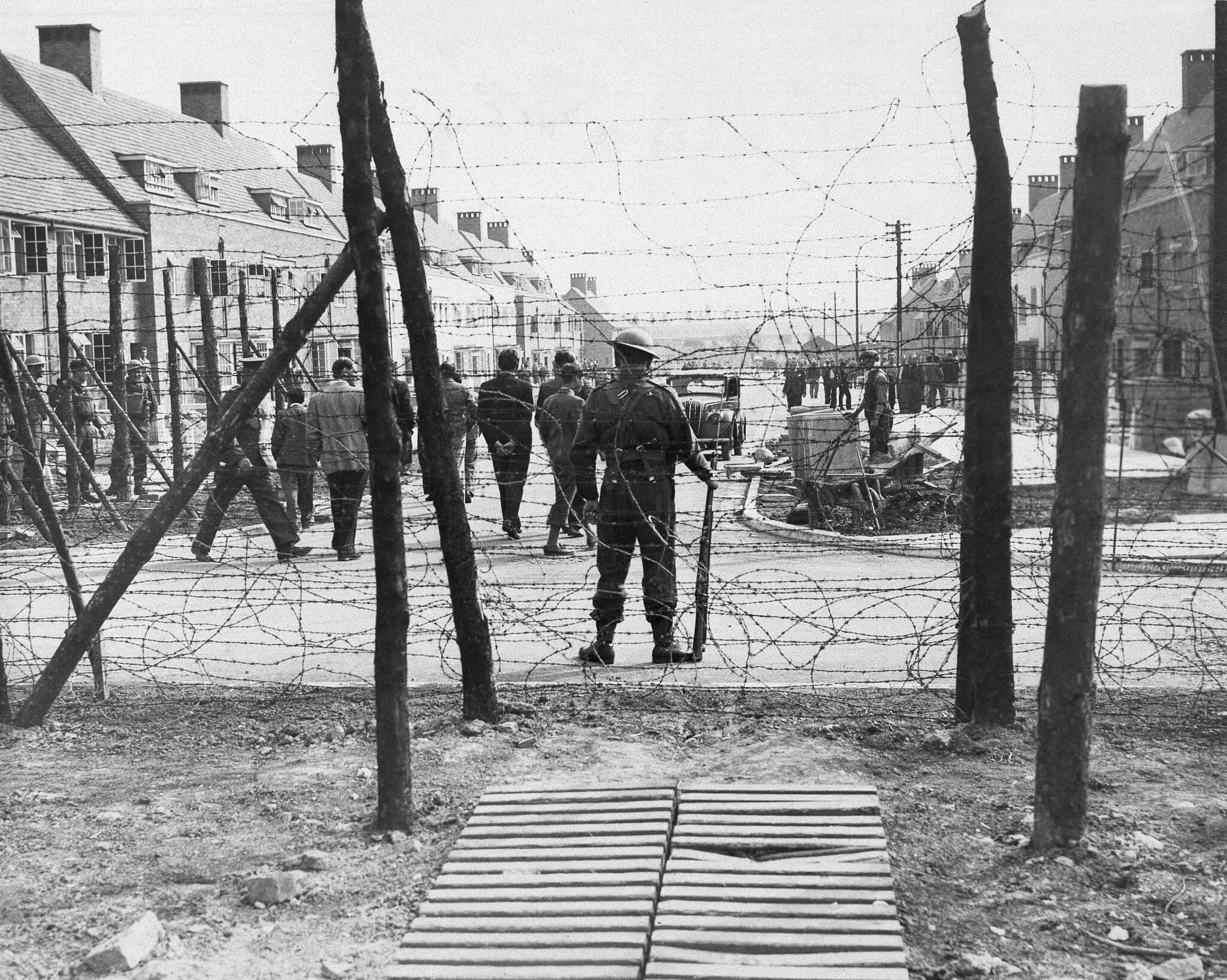 שומרים בריטים חמושים משגיחים על האסירים במחנה מעצר, 2 ביוני 1940 (צילום: AP Photo)