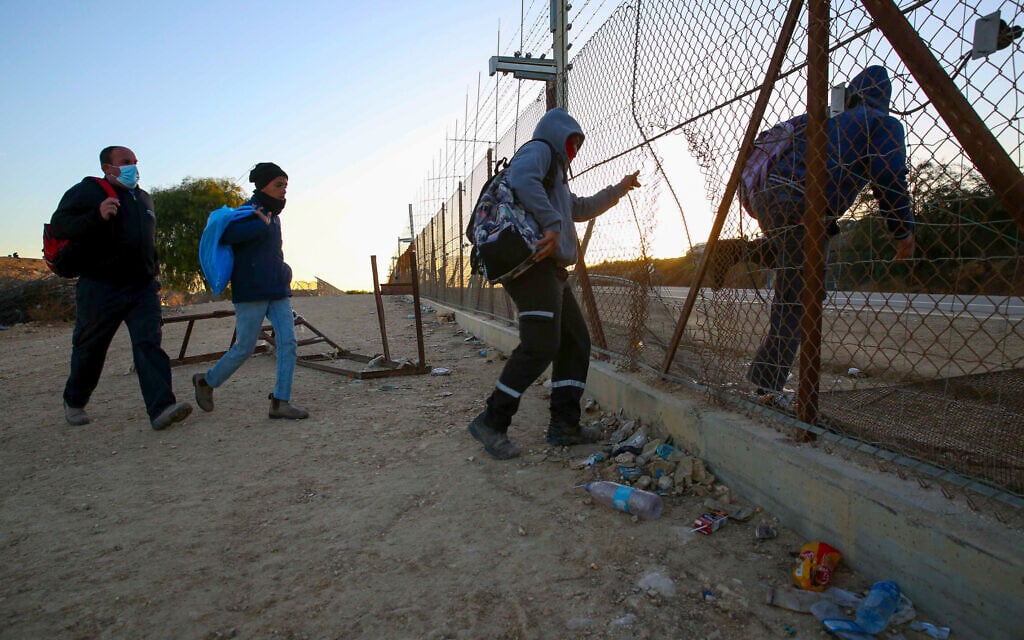 פועלים פלסטינים מחברו חוצים לישראל דרך פרצה בגדר הביטחון ליד חברון, 31 בינואר 2021 (צילום: Wisam Hashlamoun/Flash90)