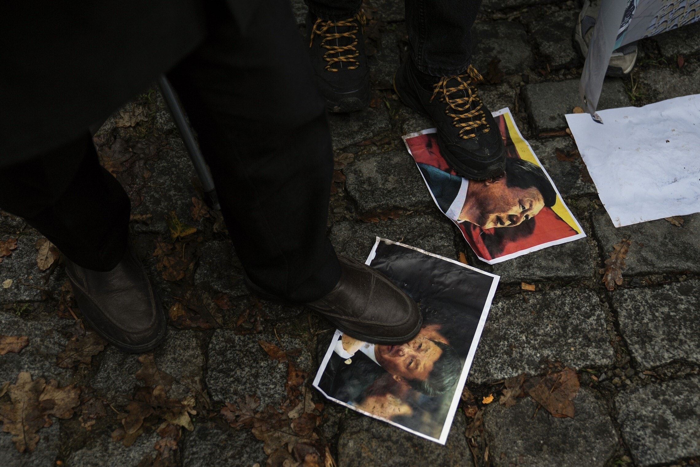 מפגינים במחאה נגד דיכוי המיעוט האויגורי דורכים על תמונת נשיא סין שי ג&#039;ינפינג, טורקיה, 30 בנובמבר 2022 (צילום: AP Photo/Khalil Hamra)