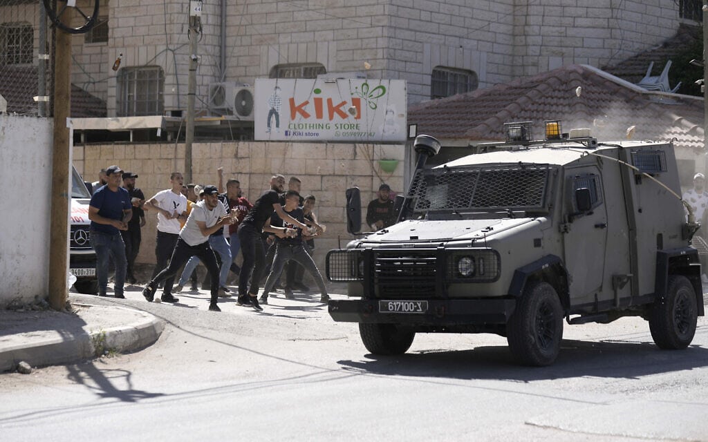 פלסטינים משליכים אבנים לעבר כוח צה&quot;ל שנכנס לפעולה בג&#039;נין, 28 בספטמבר 2022 (צילום: AP Photo/ Majdi Mohammed)