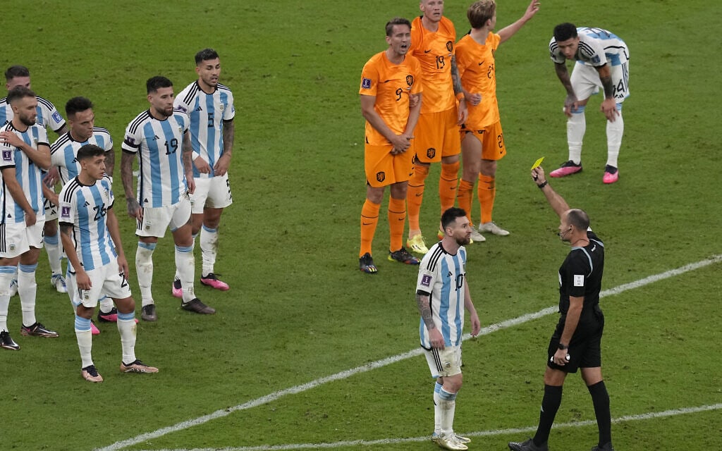 השופט שולף כרטיס צהוב לליאו מסי במשחק בין ארגנטינה והולנד ברבע הגמר של המונדיאל בקטאר, 9 בדצמבר 2022 (צילום: AP Photo/Thanassis Stavrakis)