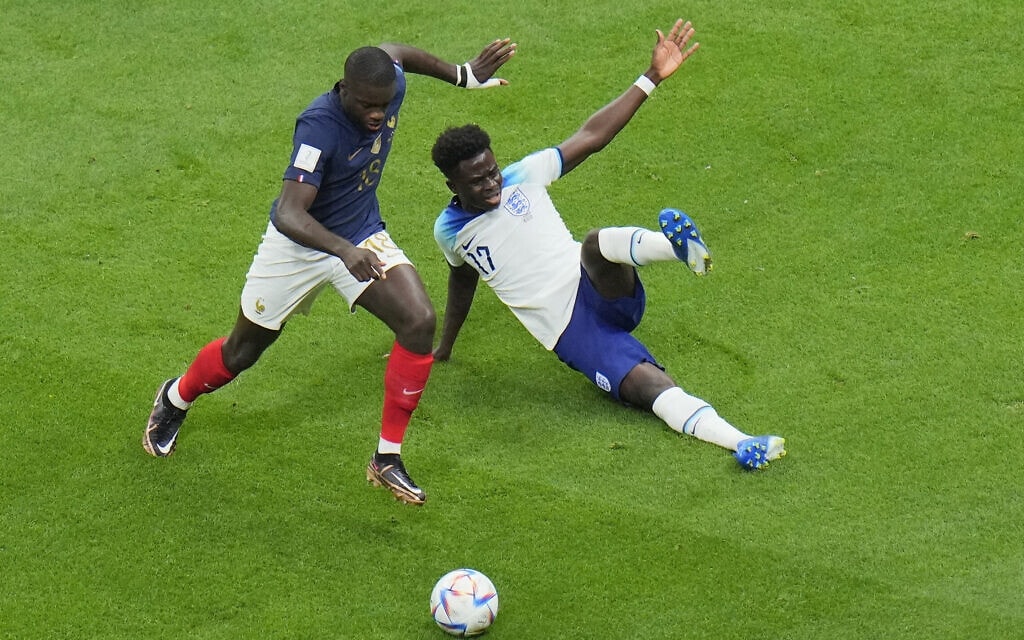 דאיו אופאמקאנו מנבחרת צרפת מכשיל את בוקאיו סאקה מנבחרת אנגליה, מה שהוביל לבעיטת עונשין עבור אנגליה, במשחק רבע הגמר של המונדיאל בקטאר, 10 בדצמבר 2022 (צילום: AP Photo/Hassan Ammar)