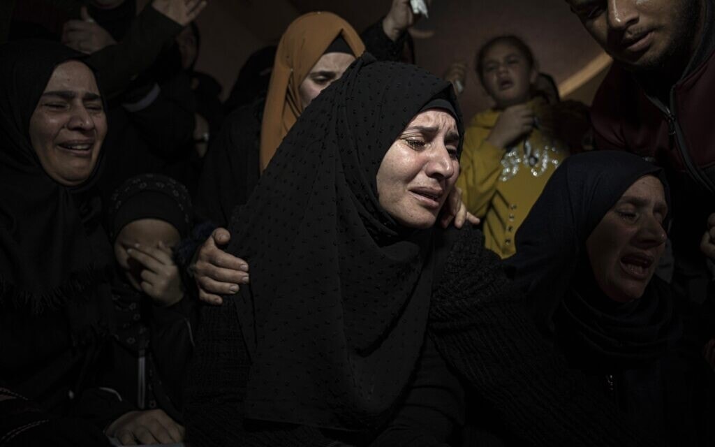 נשים בוכות בהלוויה ברצועת עזה לפליטים שטבעו ליד חופי תוניסיה, בניסיון להגיע לאירופה, 18 בדצמבר 2022 (צילום: AP Photo/Fatima Shbair)