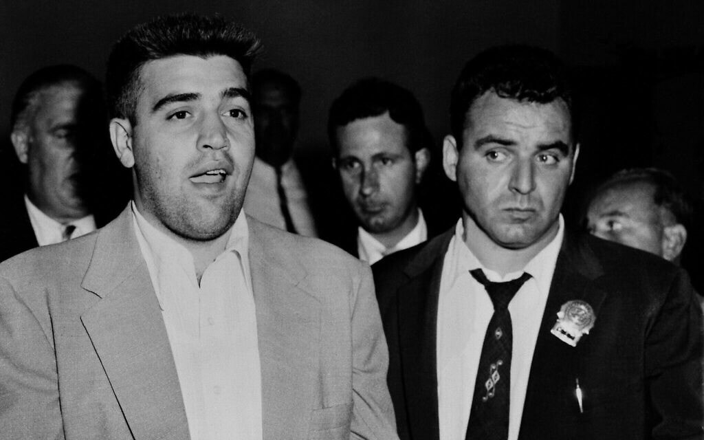 וינסנט "הסנטר" ג'יגנטה (משמאל) מובא לתחנת המשטרה ברחוב 54 בניו יורק, 19 באוגוסט 1957 (צילום: AP Photo/Matty Zimmerman)