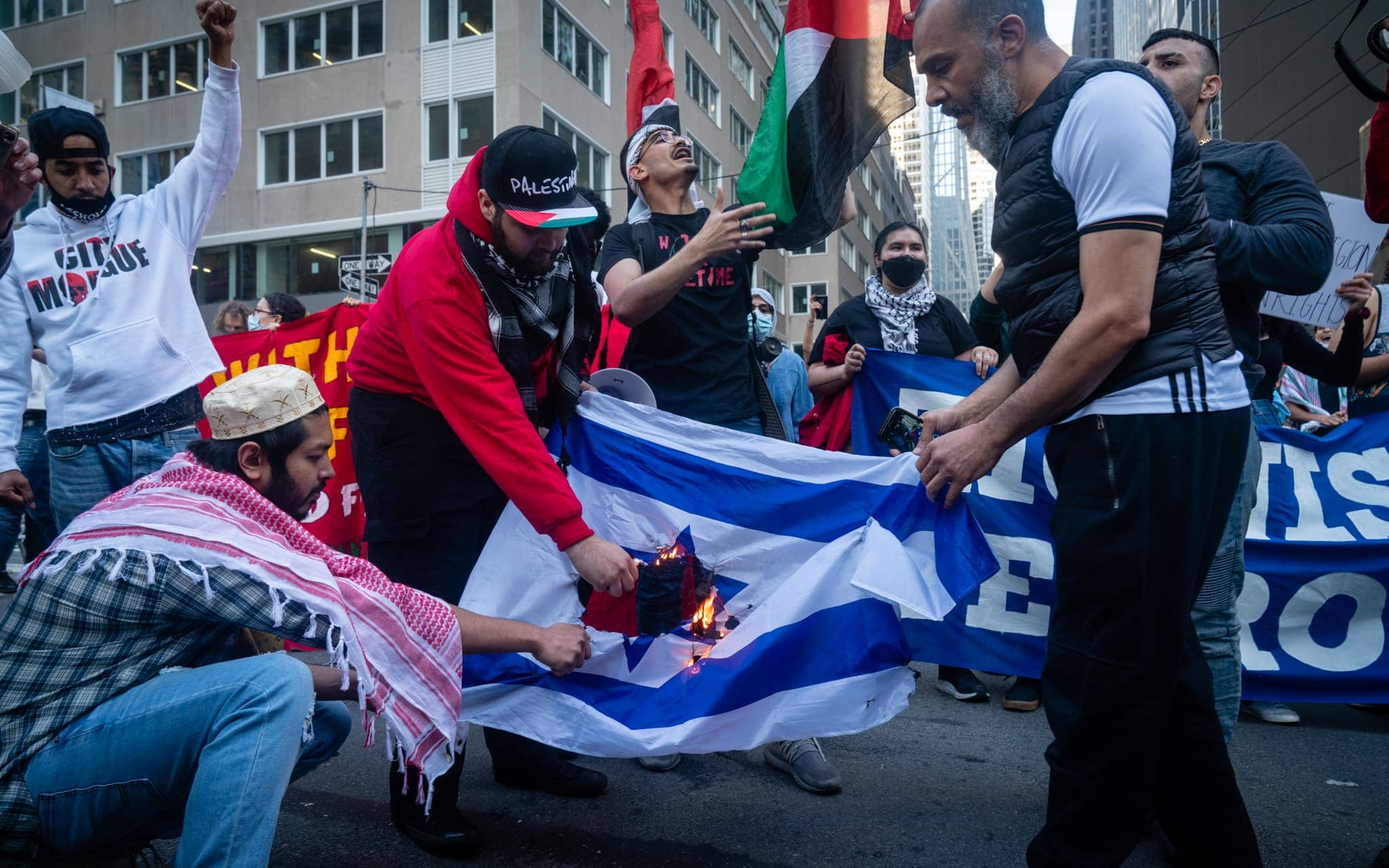 פעילים אנט־ישראלים ופרו־פלסטינים שורפים את דגל ישראל בניו יורק, 15 במאי 2021 (צילום: לוק טרס)
