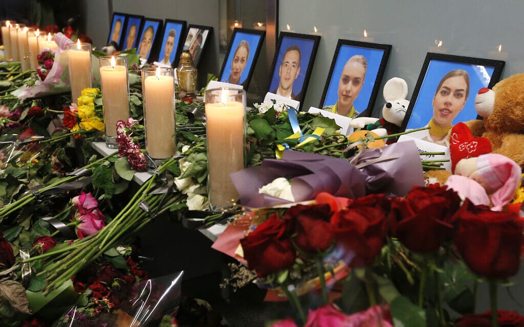 פרחים ונרות ליד תמונותיהם של צוות המטוס שהתרסק באיראן, בנמל התעופה הבינלאומי בוריספיל באוקראינה, 11 בינואר 2020 (צילום: AP Photo/Efrem Lukatsky)