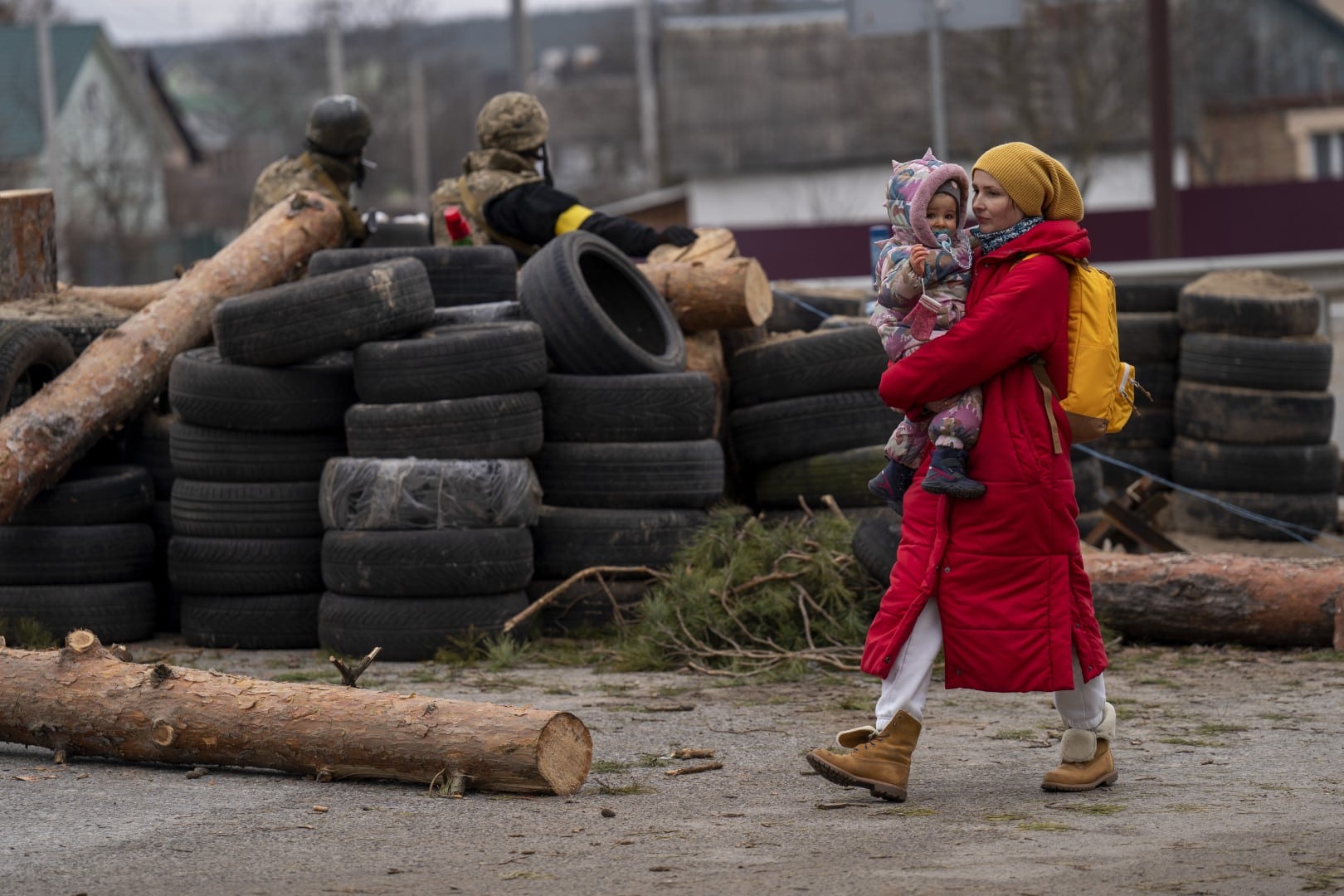 אישה אוקראינית עם תינוק חולפת על פני מחסום של הכוחות האוקראיניים ליד אירפין, אוקראינה, 5 במרץ 2022 (צילום: AP Photo/Emilio Morenatti)