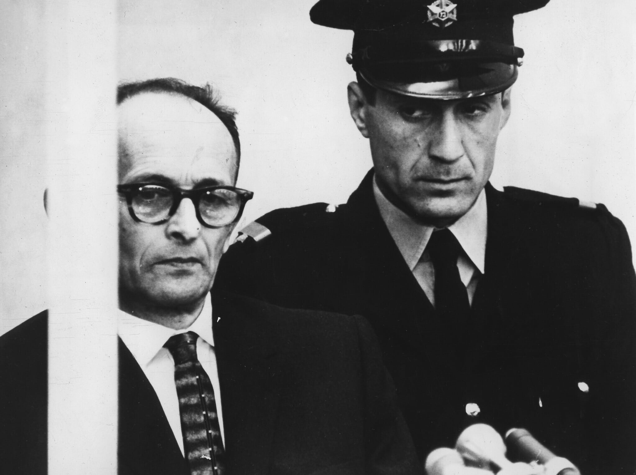 אדולף אייכמן בתא הזכוכית שלו בעת הקראת האישומים נגדו במהלך משפטו בבניין בית העם בירושלים, 12 באפריל 1961 (צילום: AP Photo/Str)