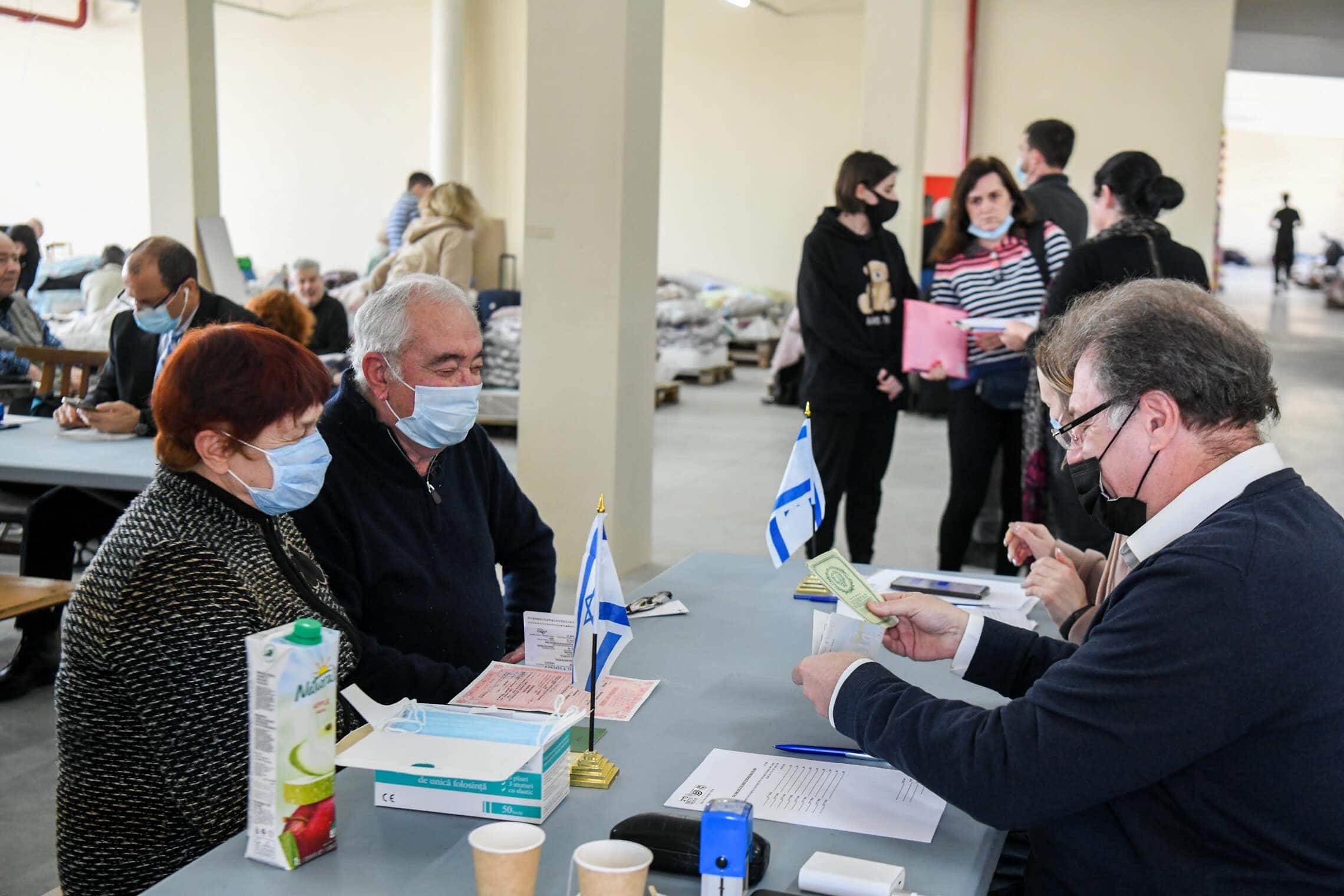 פליטים יהודים מאוקראינה מקבלים את אשרות הכניסה שלהם לישראל במקלט חירום בקישינב, מולדובה, 15 במרץ 2022 (צילום: פלאש90)