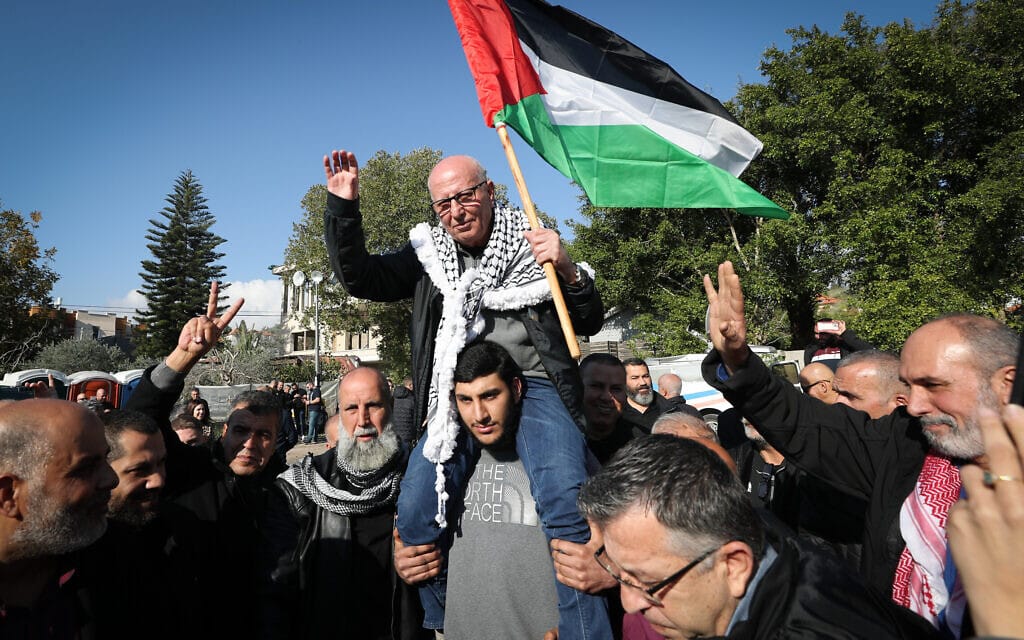 רים יונס אוחז בדגל פלסטין תוך שהוא נישא על כתפיים בחגיגות לרגל שחרורו בכפר עארה, 5 בינואר 2023 (צילום: Jamal Awad/Flash90)