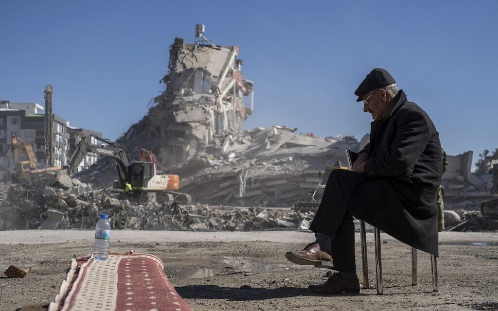 גבר בן 67 יושב על כיסא בזמן שבני משפחתו לכודים מתחת להריסות בנורדאגי, טורקיה, 9 בפברואר 2023 (צילום: AP Photo/Petros Giannakouris)