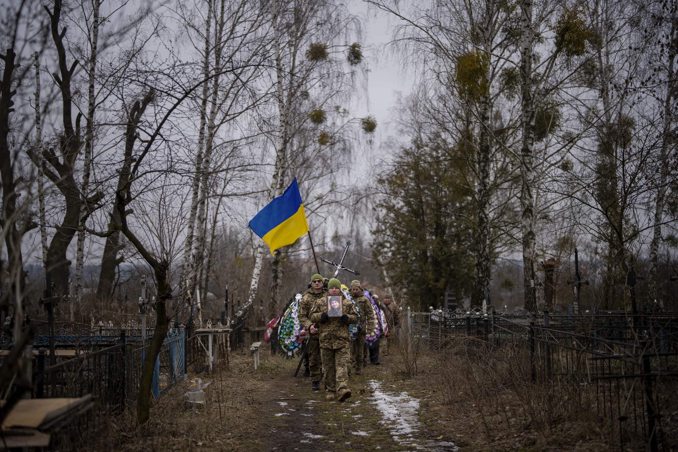 קצינים אוקראינים נושאים ארון של חייל ליד קייב, 17 בפברואר 2023 (צילום: AP Photo/Emilio Morenatti)