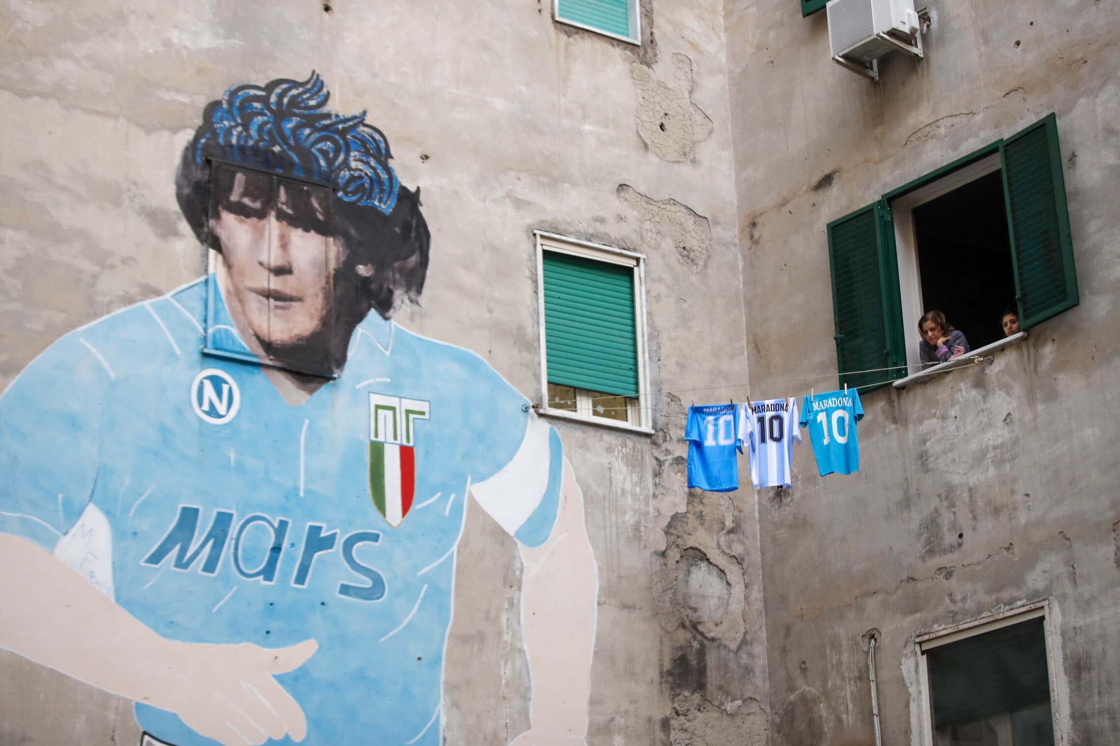 חולצה של מראדונה סמוך לקיר עם תמונה שלו בנאפולי, 26 בנובמבר 2020 (צילום: AP Photo/Alessandra Tarantino)