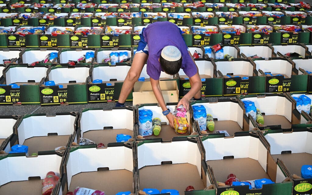אילוסטרציה: מתנדב אורז חבילות מזון עבור משפחות נזקקות, 2021 (צילום: מיכאל גלעדי/פלאש90)