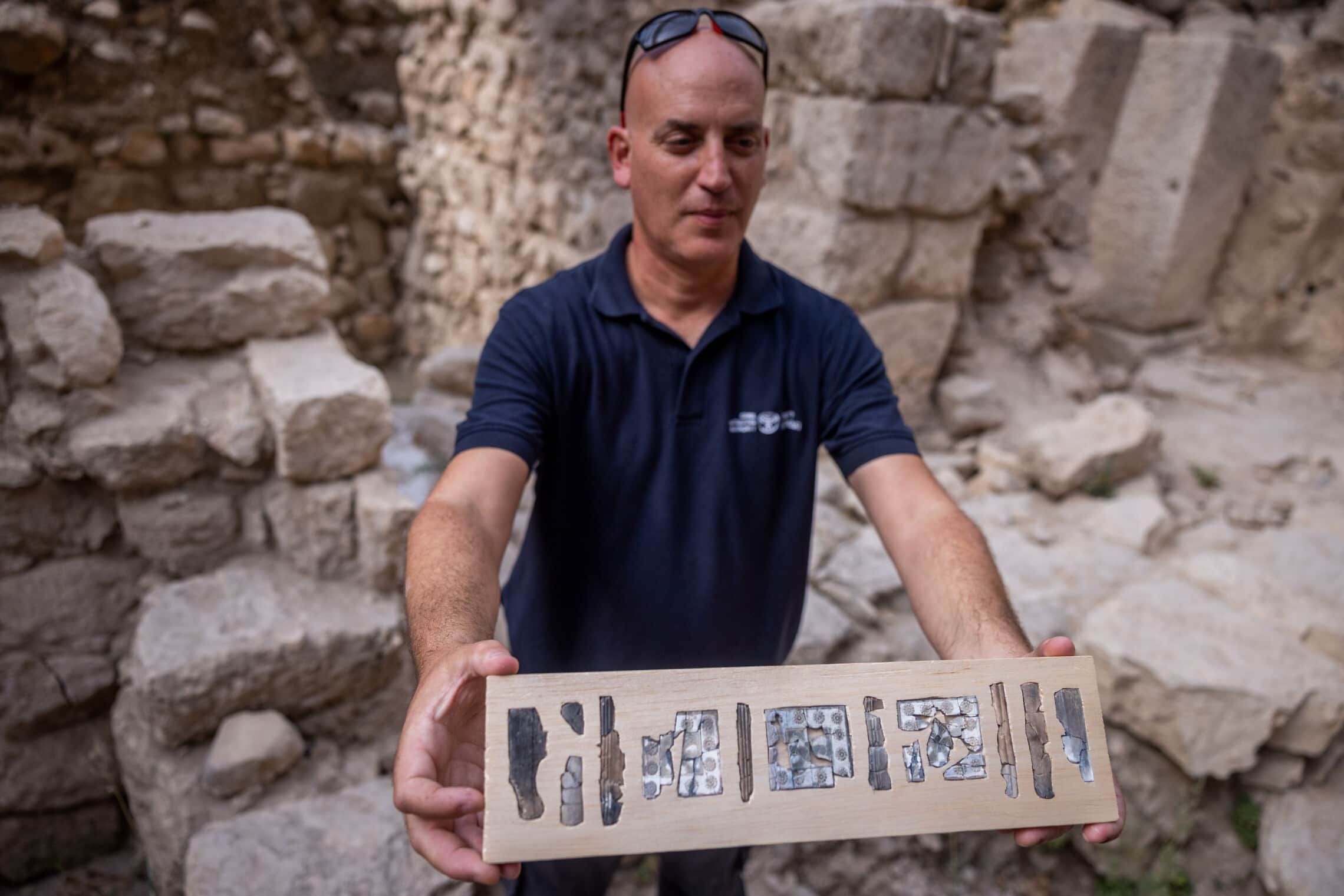 יפתח שלו מרשות העתיקות מציג סדרה של לוחות שנהב מתקופת בית ראשון בחניון גבעתי בירושלים. ספטמבר 2022 (צילום: Yonatan Sindel/Flash90)