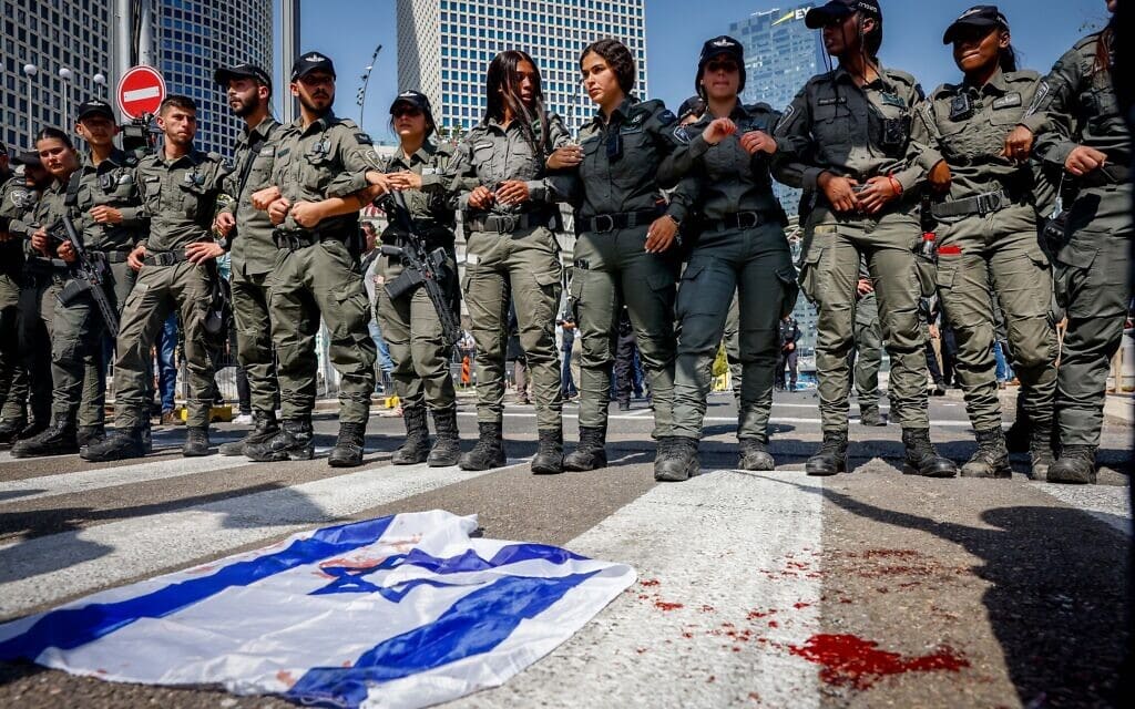 שוטרים חוסמים את הכביש בהפגנות נגד המהפכה המשפטית לצד דגלי ישראל מגואלים בדם, 1 במרץ 2023 (צילום: Erik Marmor/Flash90)