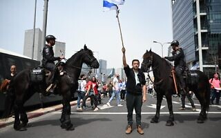 מפגין עם דגל ברחוב יגאל אלון לצד פרשי משטרה, 23 במרץ 2023 (צילום: אור פרבוזניק) מפגין עם דגל ברחוב יגאל אלון לצד פרשי משטרה, 23 במרץ 2023 (צילום: אור פרבוזניק)