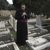 חוסאם נעום, בישוף אנגליקני פלסטיני, מבקר בבית קברות שהושחת בהר ציון בירושלים, 4 בינואר 2023 (צילום: AP Photo/ Mahmoud Illean)