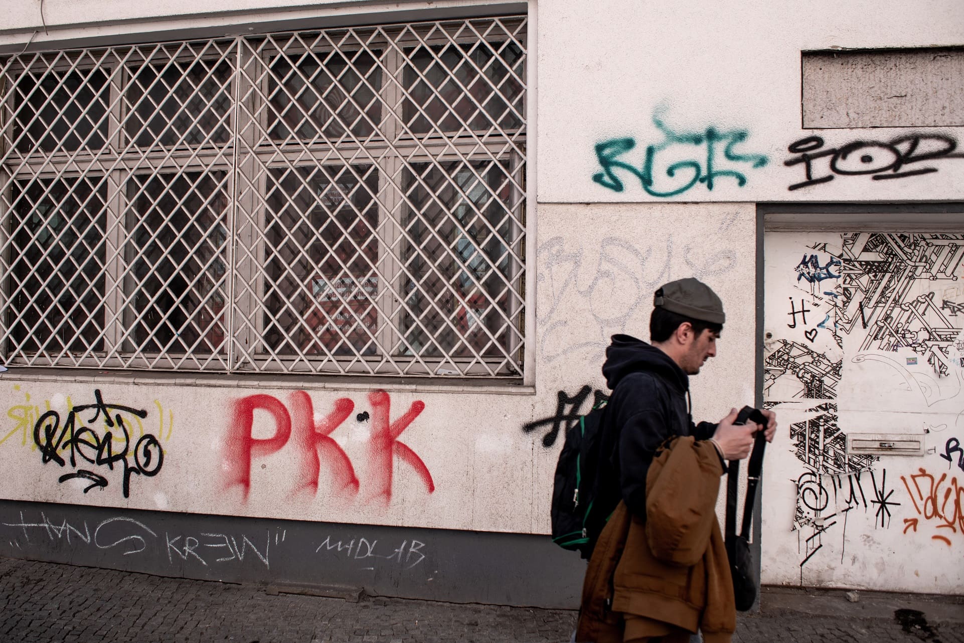 עובר אורח חולף על פני גרפיטי של ה־PKK – אחת מתנועות החופש הכורדיות הוותיקות. ברלין, גרמניה, אפריל 2023 (צילום: גילעד שדה)