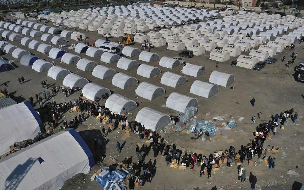 טורקים שאיבדו את בתיהם ברעידת האדמה עומדים בתור לקבל סיוע ואוכל במחנה זמני שנבנה ליד העיר איקנדרון בדרום טורקיה, 14 בפברואר 2023 (צילום: AP Photo/Hussein Malla)