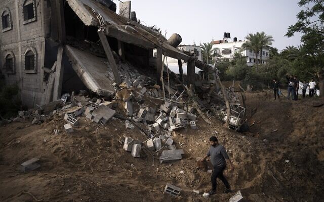 פלסטינים בודקים את הנזק שנגרם למבנה בעזה בעקבות תקיפת צה