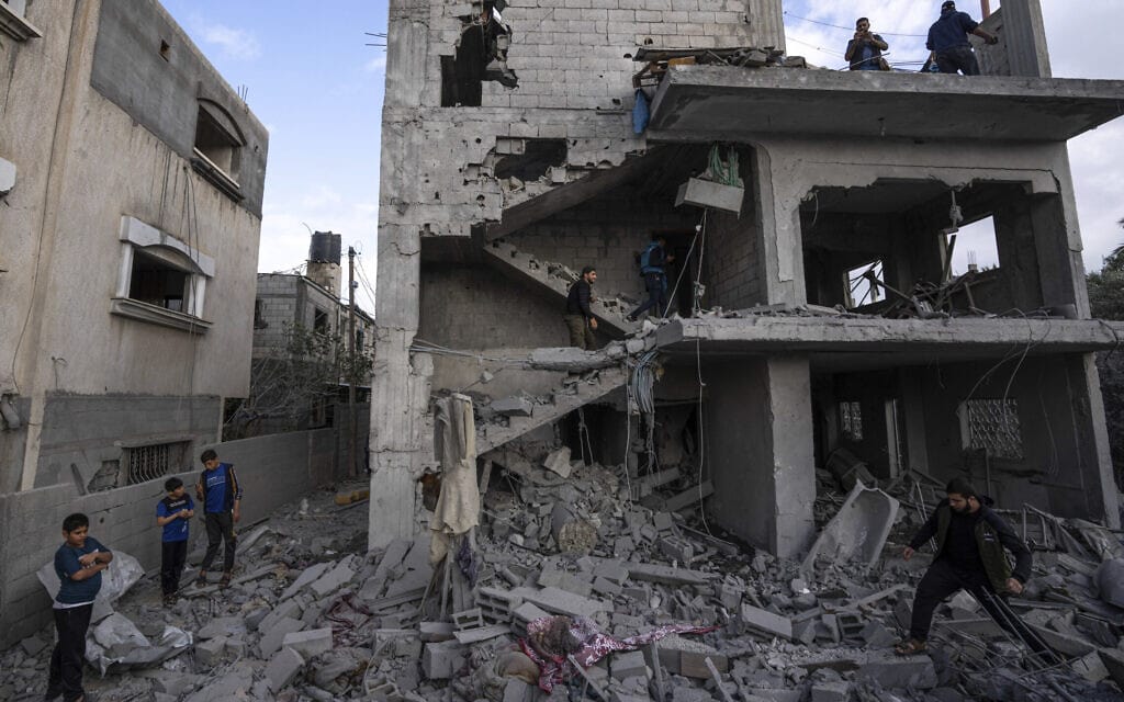 פלסטינים בוחנים את ההרס שנגרם מהפצצה ישראלית בדיר אל-בלח שבמרכז רצועת עזה, 13 במאי 2023 (צילום: Fatima Shbair, AP)