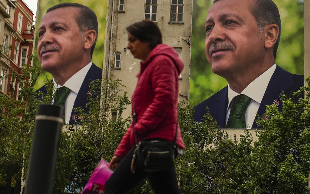 אישה חולפת על פני שלט חוצות של רג'פ טאיפ ארדואן, יום אחרי הבחירות בטורקיה, 15 במאי 2023 (צילום: AP Photo/Emrah Gurel)