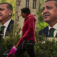 אישה חולפת על פני שלט חוצות של רג'פ טאיפ ארדואן, יום אחרי הבחירות בטורקיה, 15 במאי 2023