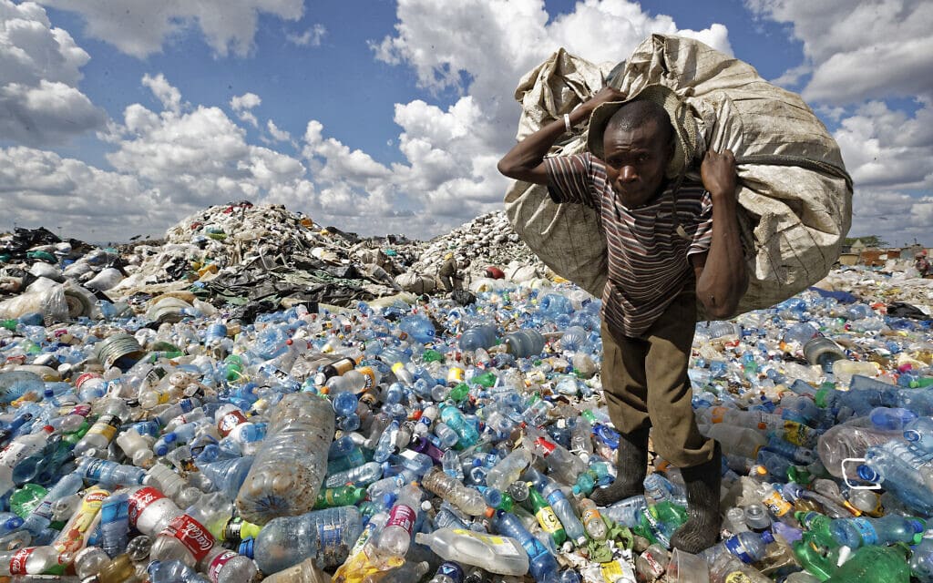 אילוסטרציה: גבר אוסף בקבוקי פלסטיק למחזור בניירובי, קניה, 5 בדצמבר 2018 (צילום: AP Photo/Ben Curtis, File)