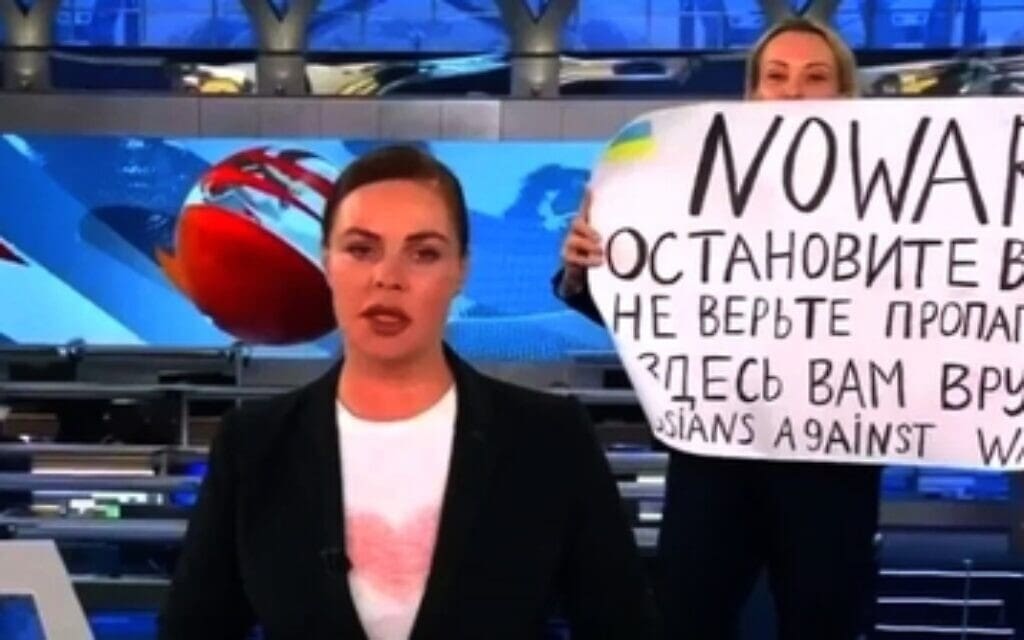 מרינה אובסיאניקווה, שדרנית בטלוויזיה הרוסית, שמחתה נגד המלחמה באוקראינה בשידור חי ונעצרה, 14 למרץ 2022 (צילום: ערוץ 1 של הטלוויזיה הרוסית. פורסם בוויקיפדיה, חופשי לשימוש הוגן העוסק במחאה נגד הפלישה הרוסית לאוקראינה)