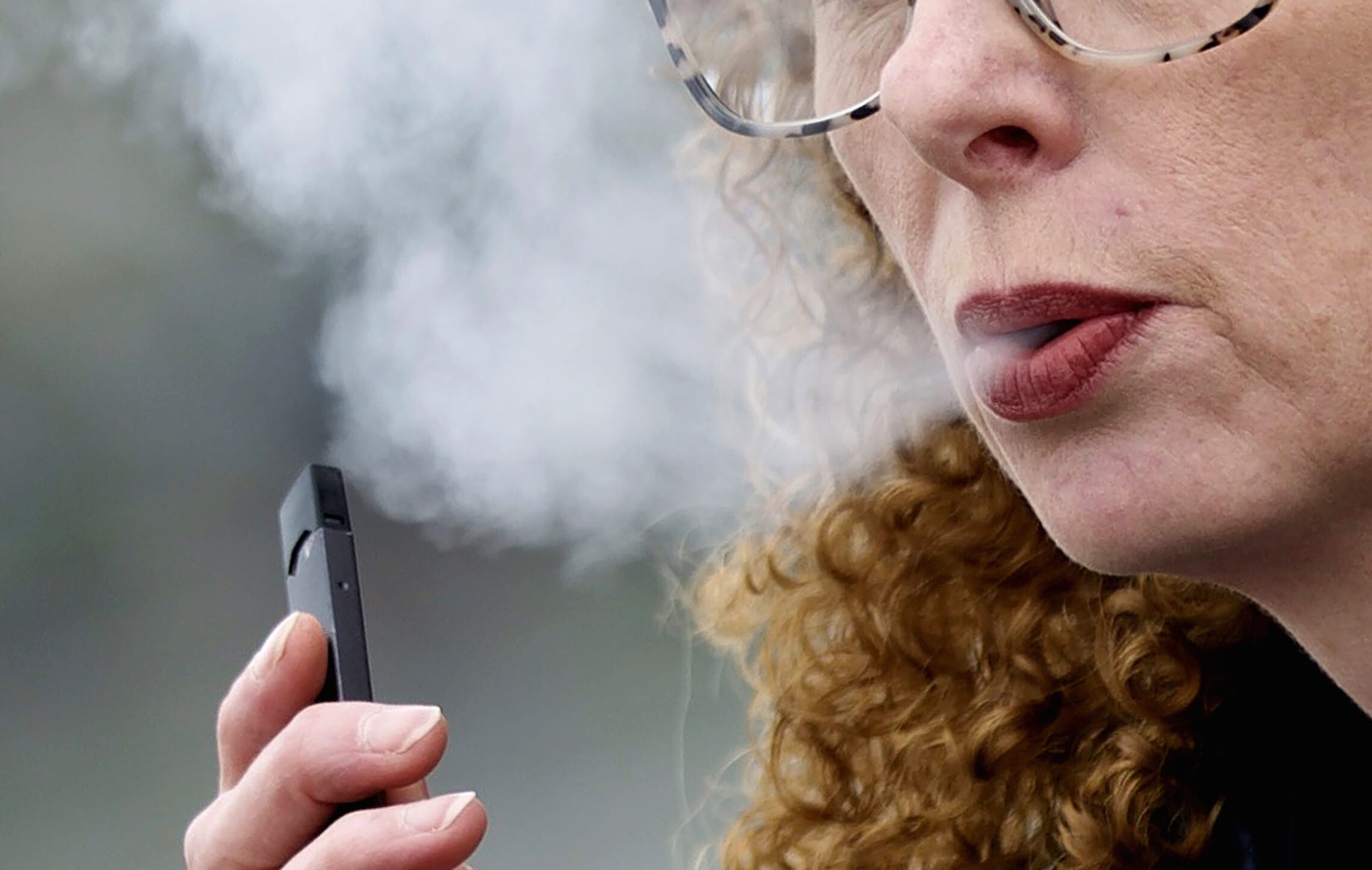 אילוסטרציה: אישה מעשנת סיגריה אלקטרונית