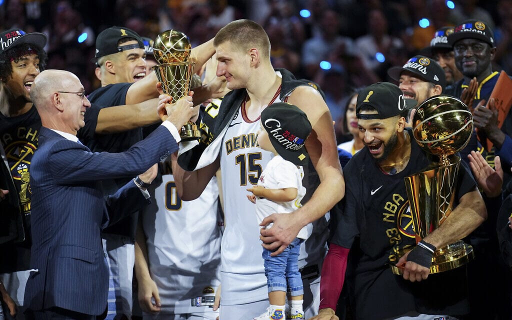 ניקולה יוקיץ&#8217; מהדנבר נאגטס מקבל את גביע ה-NBA מידי אדם סילבר, נציב הליגה. 12 ביוני 2023 (צילום: AP Photo/Jack Dempsey)
