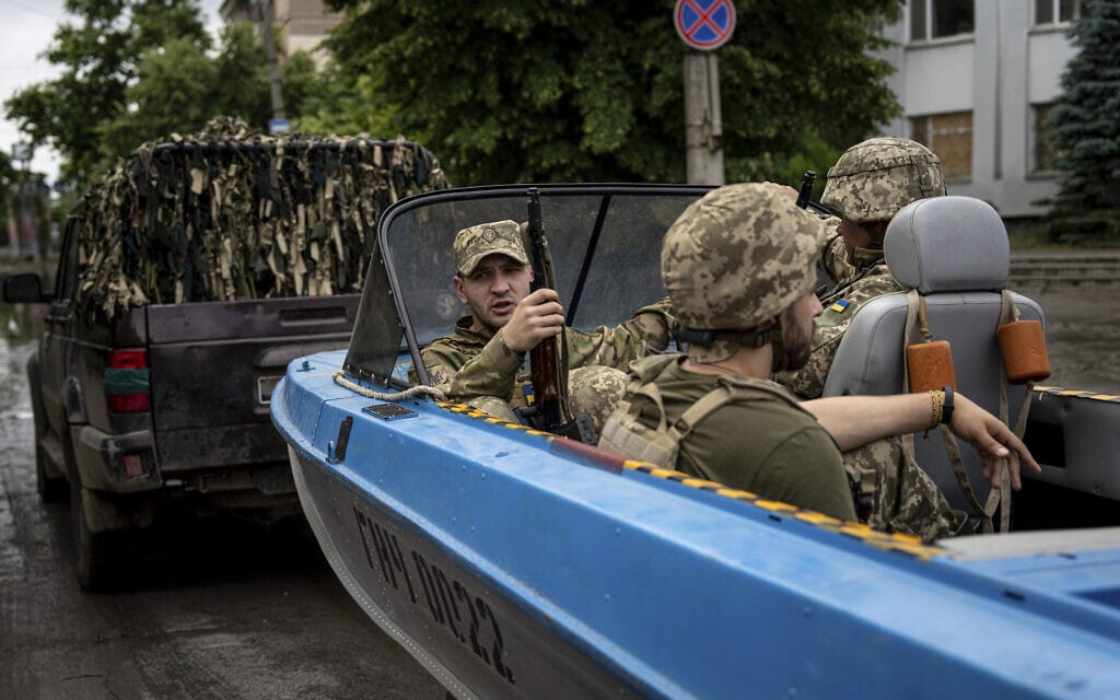 כוחות אוקראינים נשלחים לחלץ אזרחים אחרי קריסת הסכר בחרסון. (צילום: AP Photo/Evgeniy Maloletka)