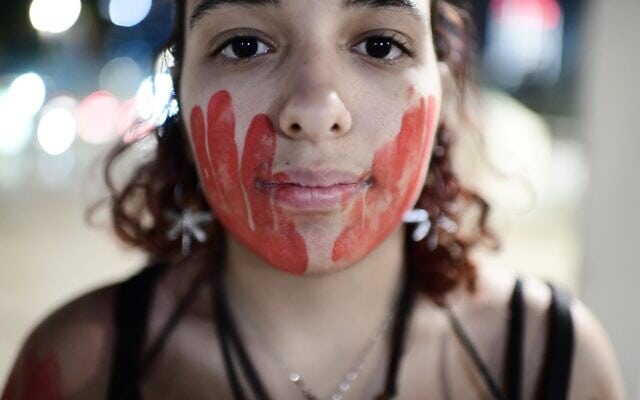 אישה במחאה לציון יום המאבק הבינלאומי באלימות נגד נשים, 24 בנובמבר 2022
