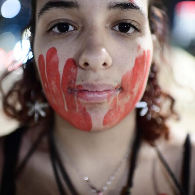 אישה במחאה לציון יום המאבק הבינלאומי באלימות נגד נשים, 24 בנובמבר 2022 (צילום: Tomer Neuberg/Flash90)
