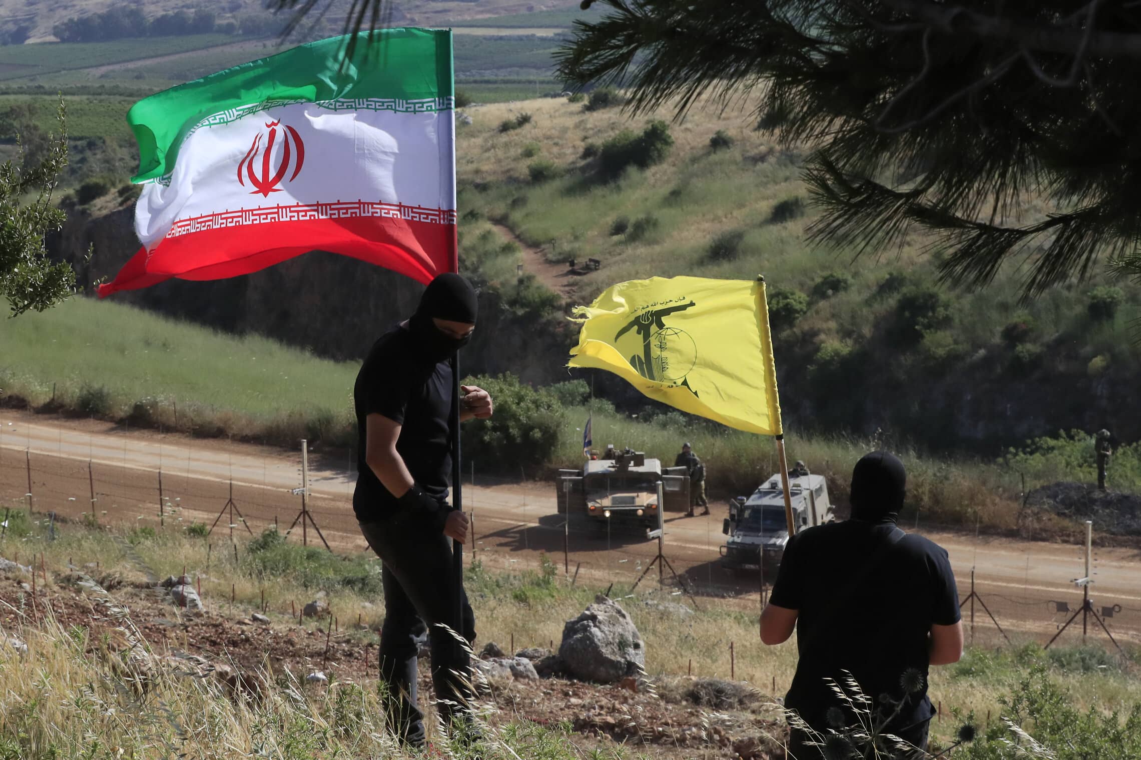 פעילי חזבאללה בדרום לבנון מניפים דגלים על הגבול עם ישראל, 25 במאי 2023 (צילום: AP Photo/Mohammed Zaatari)
