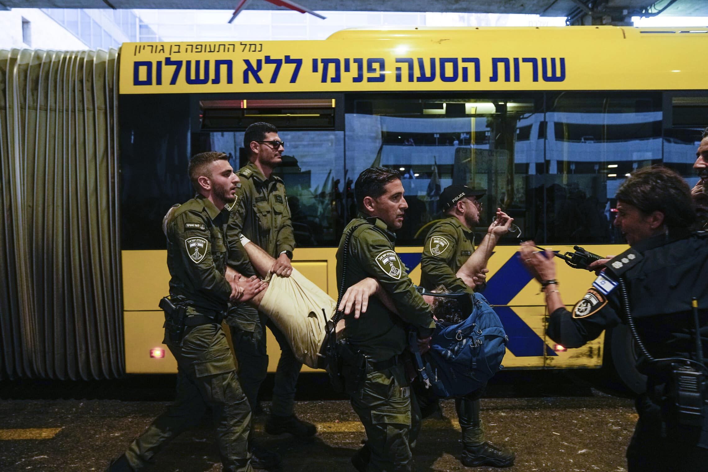 במהלך ההפגנה בנתב&#8221;ג נגד המהפכה המשפטית, שוטרים מספקים שירותי הסעה ללא תשלום לאחד המפגינים היישר אל תחנת המשטרה הסמוכה, 3 ביולי 2023 (צילום: AP Photo/Ohad Zwigenberg)