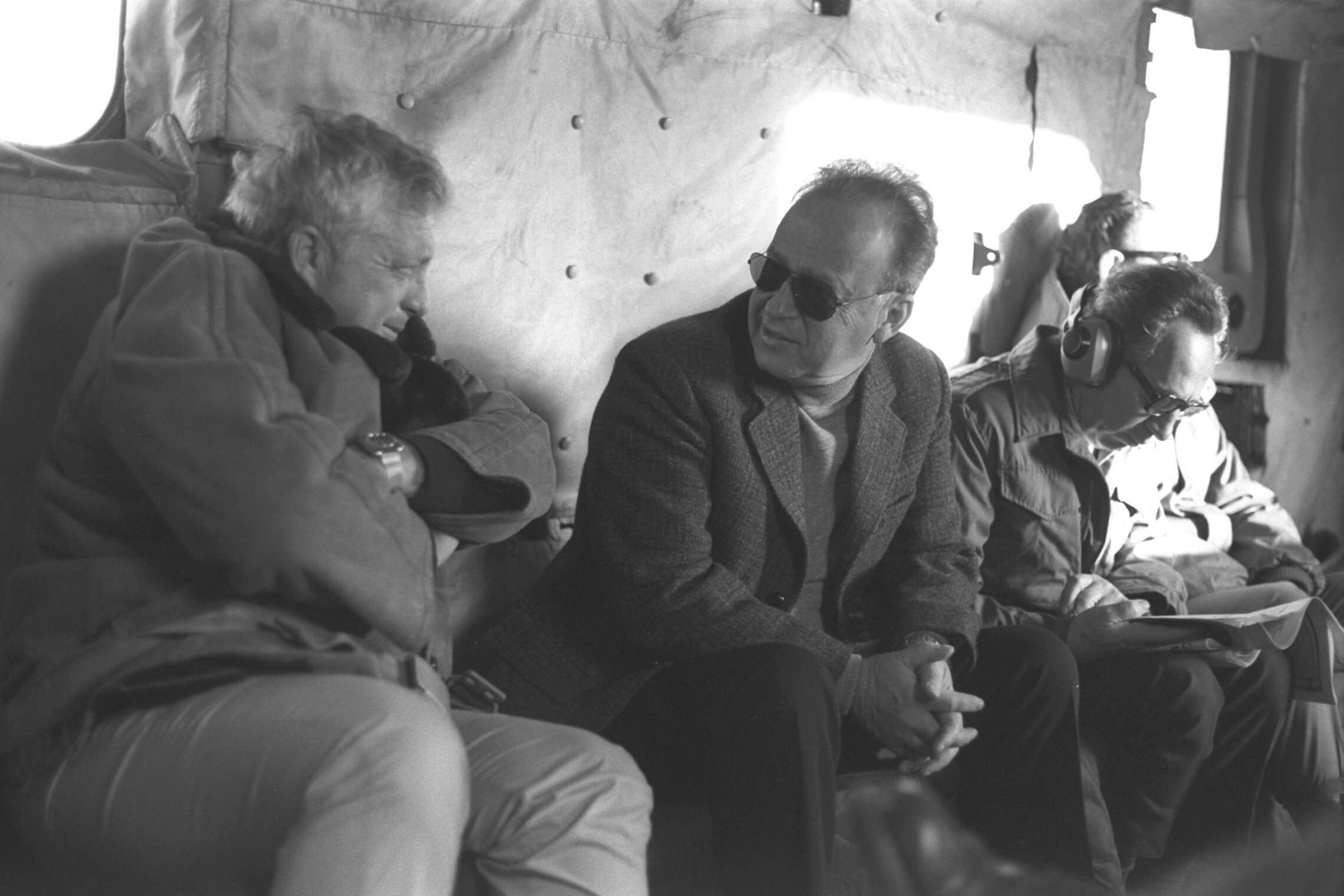 יצחק רבין עם אריאל שרון, מימין שמעון פרס קורא עיתון, בסיור ברמת הגולן ב-1975 (צילום: יעקב סער/לע&quot;מ)