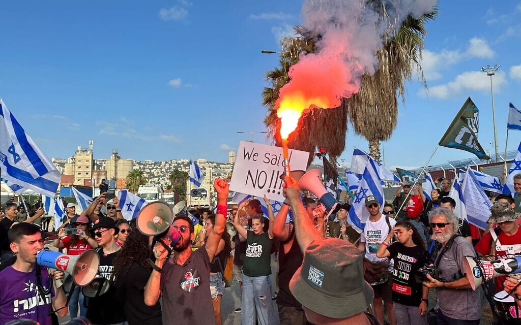 אבוקה הודלקה בהפגנה נגד המהפכה המשפטית בנמל חיפה, 3 ביולי 2023 (צילום: גבי דנציגר)