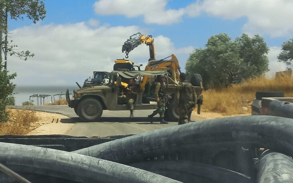 ליווי צבאי לדחפורים שמשנעים אדמה מהר עיבל לסינון בהתנחלות שבי שומרון (צילום: עמק שווה)