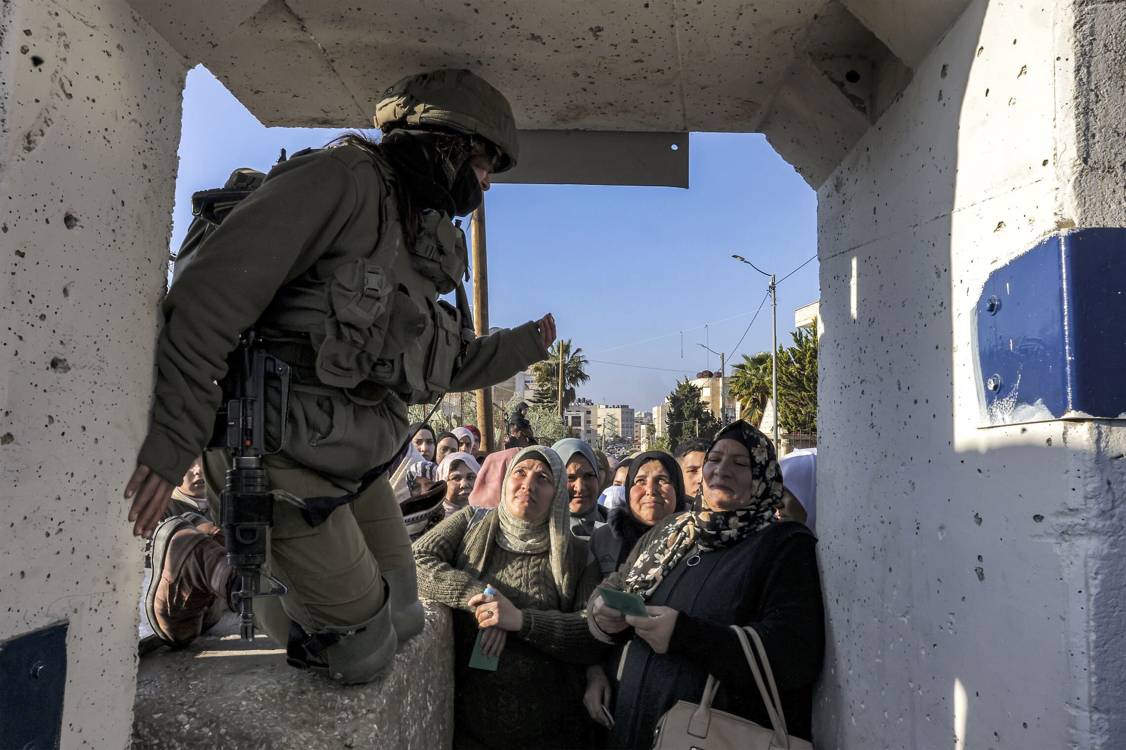 חייל צה&quot;ל מכוון פלסטינים במחסום ליד בית לחם, 14 באפריל 2023 (צילום: HAZEM BADER / AFP)