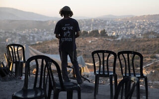 מתנחל במאחז הלא חוקי אביתר ב-30 ביוני 2021. אילוסטרציה: למצולם אין קשר לנאמר בכתבה (צילום: AP Photo/Sebastian Scheiner) מתנחל במאחז הלא חוקי אביתר ב-30 ביוני 2021. אילוסטרציה: למצולם אין קשר לנאמר בכתבה (צילום: AP Photo/Sebastian Scheiner)