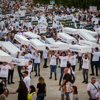 מפגינים נושאים ארונות קבורה במיצג מחאה בתל אביב נגד אוזלת היד של הרשויות בטיפולן באלימות בחברה הערבית, 6 באוגוסט 2023 (צילום: אבשלום ששוני/פלאש90)